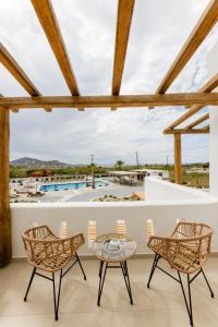 Naxos Finest Hotel & Villas في ناكسوس تشورا: فناء مع طاولة وكراسي ومسبح