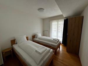 two beds in a room with a window at Swiss Holidays-City Apartments Interlaken in Interlaken
