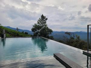 a swimming pool with a view of the mountains at Windale Resorts in Pooppara