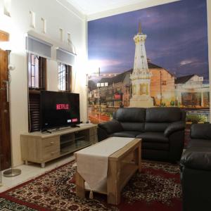 Timuran的住宿－INEZ Homestay Prawirotaman Yogya，客厅配有电视、沙发和桌子