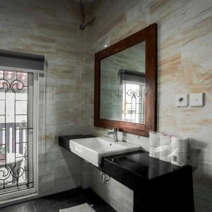 uma casa de banho com um lavatório e um espelho em INEZ Homestay Prawirotaman Yogya em Timuran