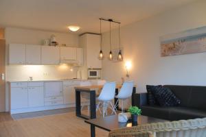 a living room and kitchen with a couch and a table at Badhotel 314 in Callantsoog