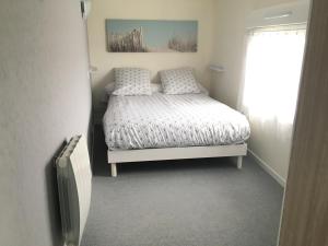 a small bedroom with a bed and a window at L'Entre Vagues in Saint-Jean-de-Monts