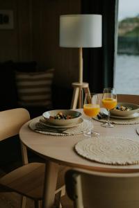 a table with two glasses of orange juice and plates of food at Palikt niedrēs in Salacgrīva