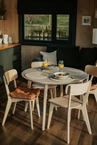 a white table and chairs with drinks on it at Palikt niedrēs in Salacgrīva