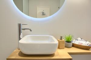 a bathroom with a white sink and a mirror at Hotel Luze El Villa in Castejón +78 photos