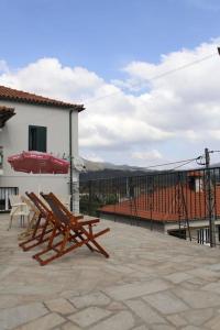 two wooden chairs sitting on a patio next to a building at Casa na Aldeia in Arcos de Valdevez