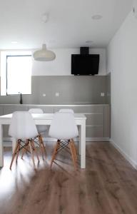 a dining room with a table and two white chairs at Casa na Aldeia in Arcos de Valdevez