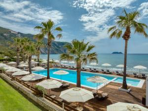 una piscina con ombrelloni e palme di Crystal Beach Hotel a Kalamákion