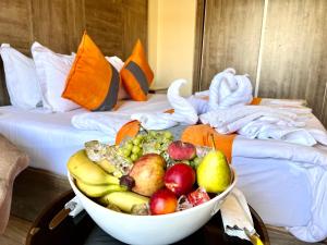 Sky Hotel في العقبة: وعاء من الفواكه على طاولة في غرفة الفندق
