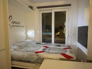 łóżko w pokoju z napisem na ścianie w obiekcie Maison du pêcheur bord de mer - 2 à 5 pers w miejscowości Saint-Raphaël +37 zdjęć