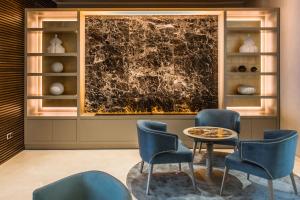 a lobby with chairs and a table and a wall withartifacts at Eurostars Diana Palace in Palencia