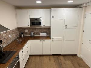 a white kitchen with white cabinets and a microwave at The Garden Madrid in Madrid