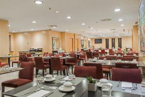 Eurostars Diana Palace في بالينثيا: غرفة طعام كبيرة مع طاولات وكراسي