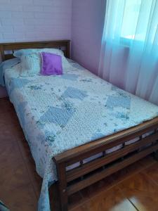 a bedroom with a bed with a purple pillow at Un lugar Para Tu Relax in Quillota