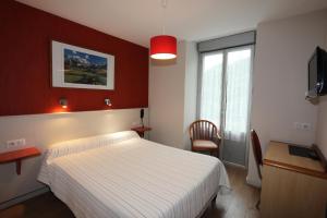 sypialnia z białym łóżkiem i czerwoną ścianą w obiekcie Hôtel Ardiden w mieście Luz-Saint-Sauveur