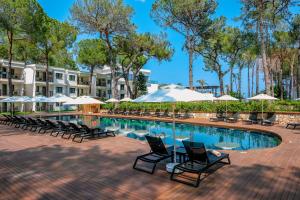 ein Pool in einem Resort mit Stühlen und Sonnenschirmen in der Unterkunft Siu Collection - Ultra All Inclusive in Beldibi