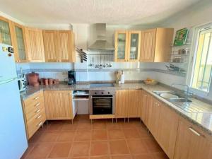 a kitchen with wooden cabinets and a white refrigerator at Casa Diana in Loja