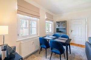 une salle à manger avec une table et des chaises bleues dans l'établissement Villa Albus App 9, à Ahlbeck