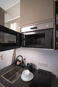 a kitchen with a sink and a microwave at Barockes Wohnen am Marktplatz-Stadtmitte in Würzburg +6 photos