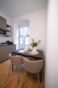 a dining room with a table and chairs and a kitchen at Barockes Wohnen am Marktplatz-Stadtmitte in Würzburg