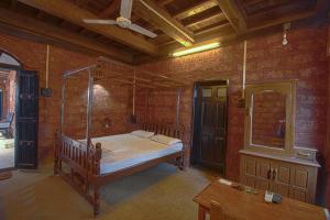 ein Schlafzimmer mit einem Bett in einem Zimmer mit Ziegelwänden in der Unterkunft Konkan Nest Resort in Ganpatipule