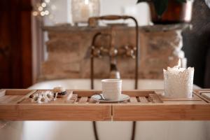 Una mesa de madera con dos tazas y una vela. en Baita Naturas con piscina idromassaggio calda, privata e gratuita, en Rossana 52 fotos más