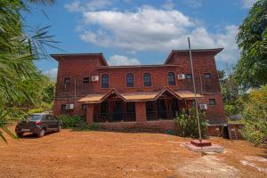 甘帕普拉Konkan Nest Resort的一栋砖房，门前停着一辆车
