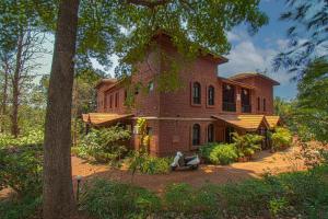 甘帕普拉Konkan Nest Resort的一栋砖房，门前停着一辆轻便摩托车