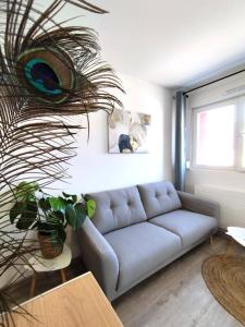 Una sala de estar con un sofá y una planta. en Home Sweet Metz & Place de parking privée, en Metz