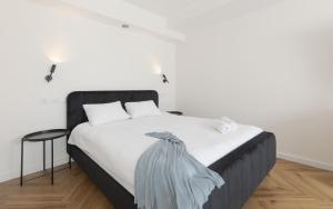 una camera con letto bianco e testiera nera di סוויטות עם נוף צמודות לים במתחם SeaSide היוקרתי עם בריכה - By SEAELO EILAT a Eilat Altre 22 foto