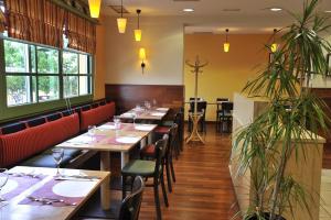 un restaurant avec des tables en bois, des chaises et des plantes dans l'établissement Travelodge Murcia, à Murcie