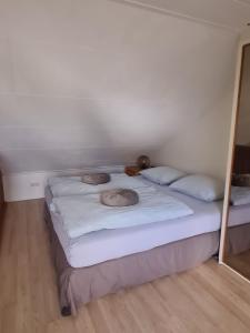 Romantisch Gastenverblijf في لونتيرين: غرفة نوم بسريرين مع شراشف بيضاء ومرآة