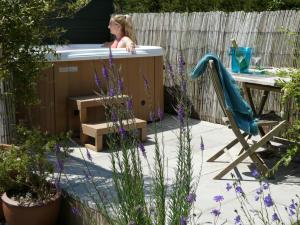 a woman sitting in a bath tub in a garden at Bracken in Converted Barn in Dundon +1 photo