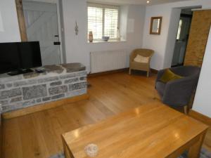 a living room with a tv and a couch and a table at Bracken in Converted Barn in Dundon