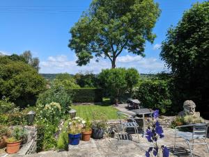 a garden with a table and chairs and flowers at Bracken in Converted Barn in Dundon