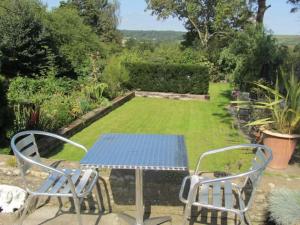a table and chairs on a patio with a garden at Bracken in Converted Barn in Dundon