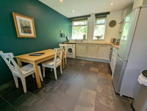a kitchen with a wooden table and a refrigerator at Bracken in Converted Barn in Dundon