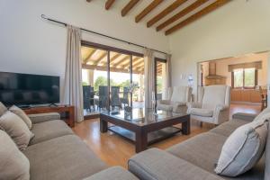 ein Wohnzimmer mit einem Sofa und einem Couchtisch in der Unterkunft Villa Coira in Alcúdia