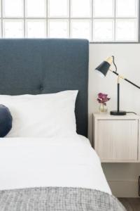 1 dormitorio con cama y mesita de noche con lámpara en EIGHT TWO NINE TWO IV: BONDI BEACH, en Sídney