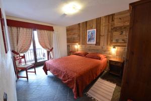 sypialnia z łóżkiem w pokoju z drewnianymi ścianami w obiekcie Residence Au Vieux Grenier w mieście Cogne