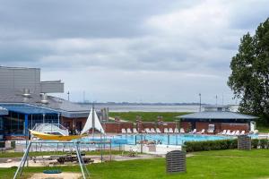 a swimming pool with a boat in front of a building at Fewo Strandmuschel in Dangast