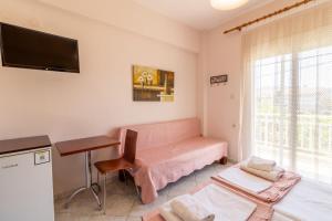 a living room with a pink couch and a desk at Iliadis House in Sarti