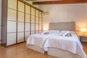ein Schlafzimmer mit einem großen weißen Bett mit zwei Kissen in der Unterkunft Villa Coira in Alcúdia