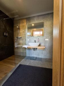 La salle de bains est pourvue d'un lavabo et d'une douche. dans l'établissement Domki Nie Całkiem Święte, à Smerek