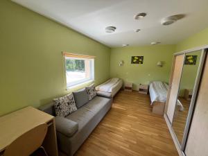 a living room with a couch and a window at Alutaguse Tervisespordikeskuse Päikesemaja in Vasavere