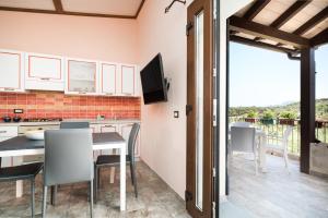 cocina con mesa y sillas y TV en casa Stella, en Dorgali