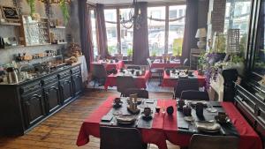 een eetkamer met tafels met rode tafelkleden bij "Chez Ba'Nus" in Blankenberge