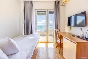 um quarto de hotel com uma cama e uma televisão de ecrã plano em Villa Tino em Ohrid