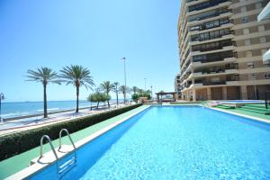 a swimming pool with a view of the beach and a building at Castellmar vista mar Orangecosta in Benicàssim +19 photos